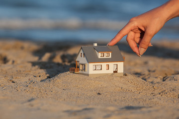 Real estate concept. Model house on the sandy beach. Blur Background