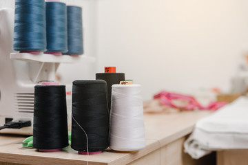 Closeup photo of threads coils on table in designer studio