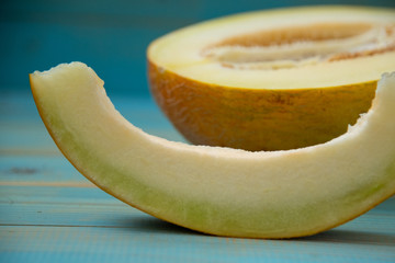 half ripe melon on a rustic, blue wooden background
