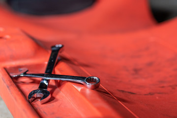Auto repair shop tools on a creeper in a garage