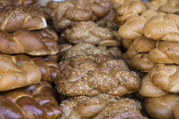Background of loaves of fresh white bread with sesame seeds close-up on the shelf in the market