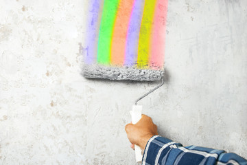Painting of walls with a roller with multi-colored rainbow colors