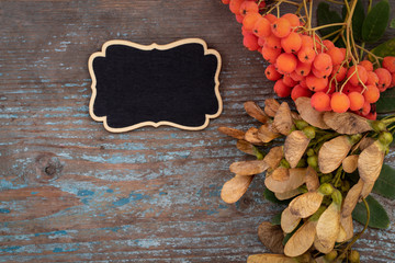 Autumn background from fallen leaves and fruits with vintage place setting on old wooden table. Thanksgiving day concept