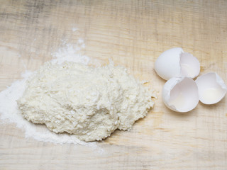 Cottage cheese, baking flour, eggs on wooden rustic table. Top view of culinary background.