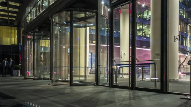  the flow of people passing through the revolving door of the modern office building at the end of the working day,time lapse