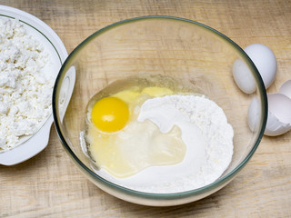 Cottage cheese, baking flour, eggs on wooden rustic table. Top view of culinary background.