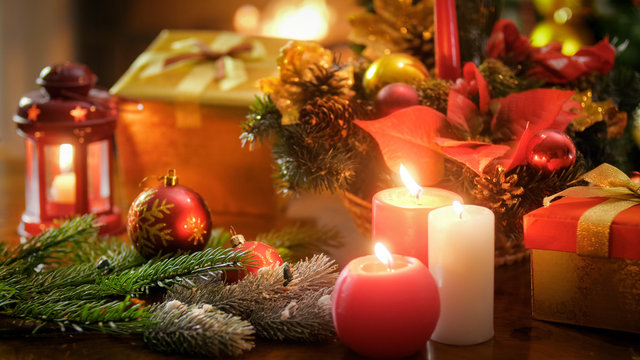 Beautiful image for winter holidays with candles, baubles and gift boxes