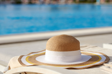 Bonnet hat on sunbed against swimming pool.