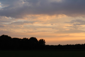 Fototapeta na wymiar Zonsondergang - fraaie wolken lucht tijdens een lichte regen bui