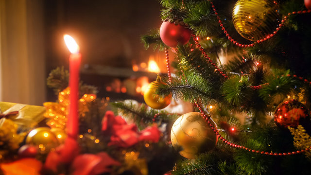 Closeup image of beautiful golden and red baubles hanging on Christmas tree branches