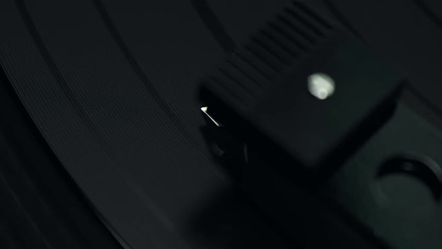 Turntable stylus tracking a vinyl record in close-up detail
