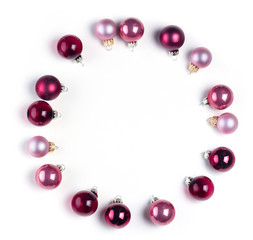 Christmas flat lay scene with frame of pink abd violet glass balls over white