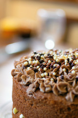 Top of brown iced cake sprinkled with multi-coloured beads