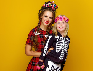 mother and child in halloween costume on yellow background