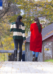 autumn, two girls walk along the sidewalks
