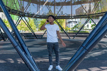 young handsome african american talking mobile while walking