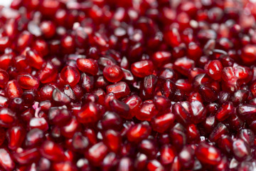 Red background of pomegranate seeds close-up