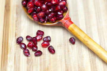 delicious berry pomegranate on a wooden spoon