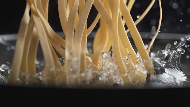 Throwing linguine noodle in water. Shot with high speed camera, phantom flex 4K. Slow Motion.