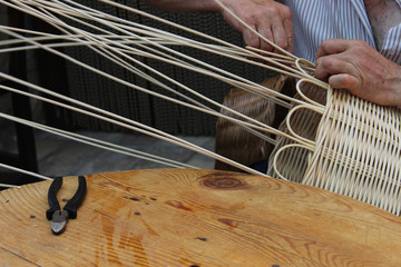 Artesano realizando una cesta de mimbre de manera manual
