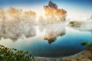 Fog in the nature. Captivating misty landscape of sunrise scene over the winding tranquil river....