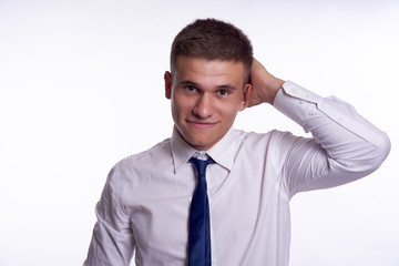 a handsome man in a white shirt and tie with his left hand scratches the back of his head