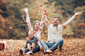 Happy family having fun in autumn forest