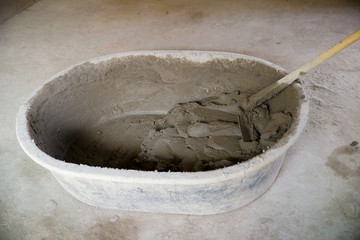 bucket of mixed cement mortar for plaster wall or welding brick. image for building construction concept.