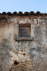 Rustic old wooden hatch on stone building with tiled roof