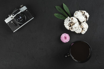 Top view on black background with coffee, cookies and vintage photo camera. Flat lay with copy space for your text