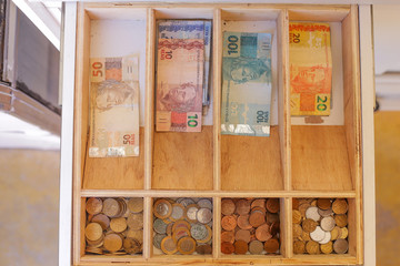 drawer with Brazilian money notes and coins.