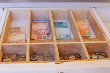 drawer with Brazilian money notes and coins.