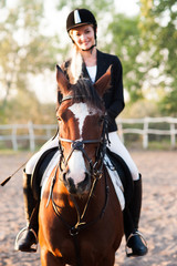 Fototapeta premium A beautiful girl rider drives a horse. Horse theme