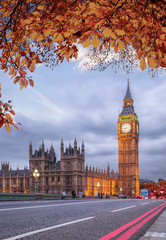 Fototapeta na wymiar Buses with autumn leaves against Big Ben in London, England, UK