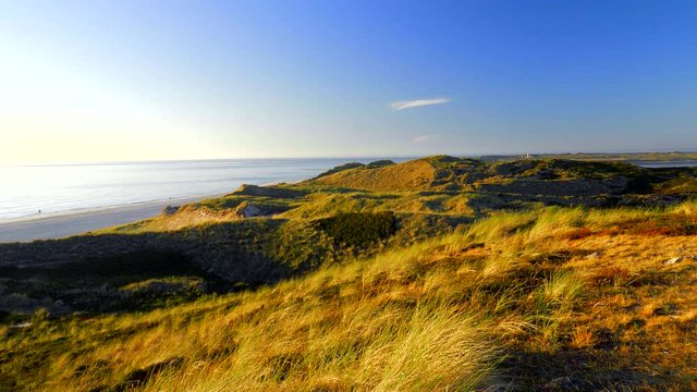 Wundersch&ouml;ner Blick &uuml;ber die D&uuml;nen - Landschaft von Sylt auf das Meer. Im Hintergrund der Leuchtturm von List