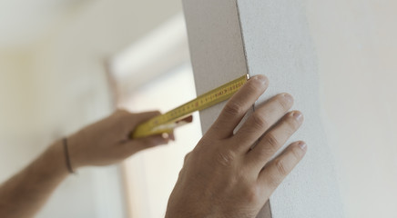 Man measuring a wall using a folding ruler