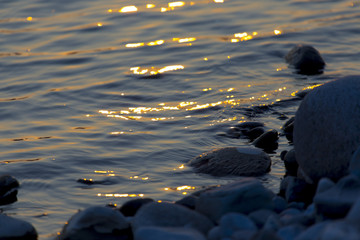 the stream of water during sunset and the beautiful stones on it