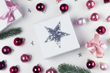 Christmas flat lay scene with star, pink and violet glass balls and presents
