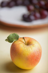 Apple with grapes in background