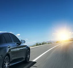 Crédence de cuisine en verre imprimé Voitures rapides Black car rushing along a high-speed highway in the sun.