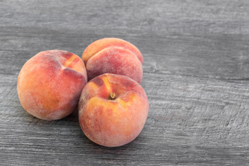 Fresh, ripe peaches on wooden background