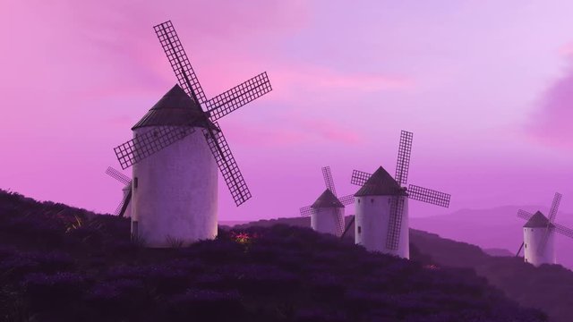 Multiple white, classic spanish windmills in the field during beautiful sunset.