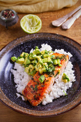 Salmon fillet with avocado lime coriander salsa, rice as a garnish. vertical