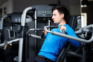 Schulterpresse, Mann macht eine Übung für die Schultern im Fitnessstudio