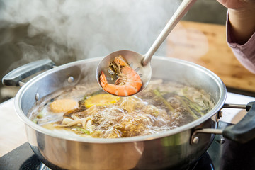 Shabu Shabu and Sukiyaki black soup, show squid slice on ladle. healthy food japanese style. image for objects and copy space.