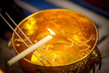 Buddha monk hold candlestick above holy water bowl. religion ceremony. Buddhist holy water. image...