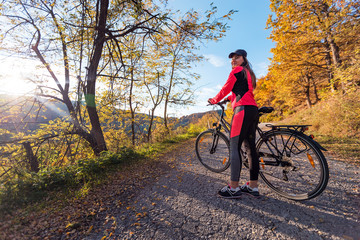 Plakat Active woman riding bicycle at autumn day