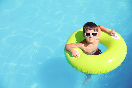Little boy with inflatable ring in swimming pool