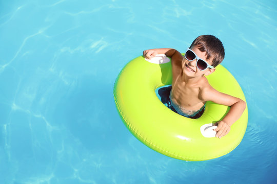 Little boy with inflatable ring in swimming pool