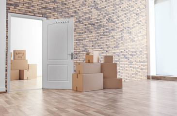 Fototapeta premium Pile of moving boxes in empty room